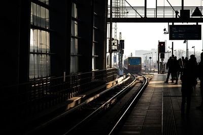 Railroad tracks in city against sky