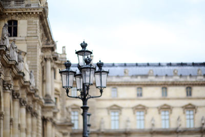 Lamp post by building against sky