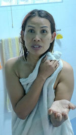 Close-up portrait of a smiling young woman in bathroom