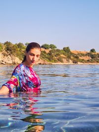 Portrait of woman against sea against clear sky