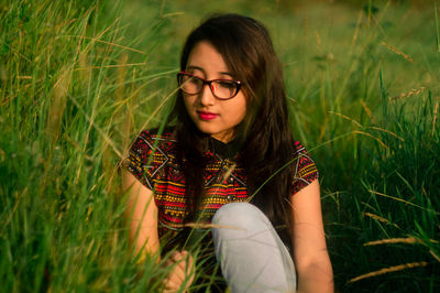 Young woman sitting amidst grass