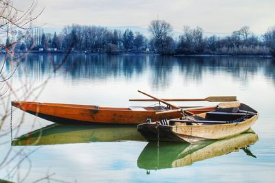 Boat moored in lake against sky