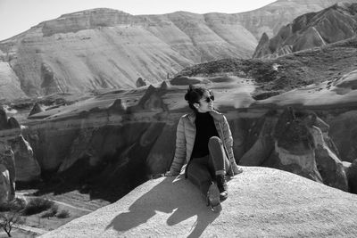 Rear view of woman standing on rock formations