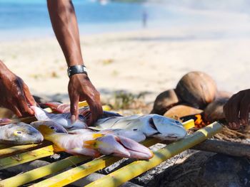 Hand pick up grilling fish on the beach