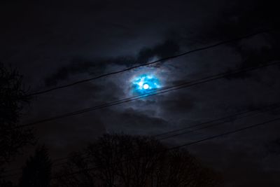 Low angle view of power lines against cloudy sky