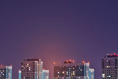 Multistorey buildings at night lights, copy space. long exposure photography, stars tracks in sky