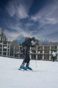 Rear view of people walking on snow covered field against sky