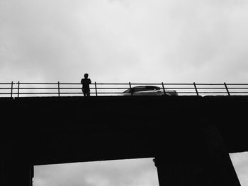 Low angle view of silhouette bridge against sky