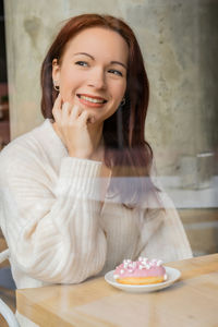 Portrait of smiling young woman in cake