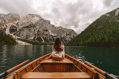 Woman in boat on lake against mountains