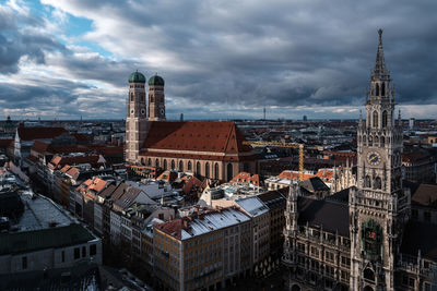 High angle view of buildings in city against cloudy sky