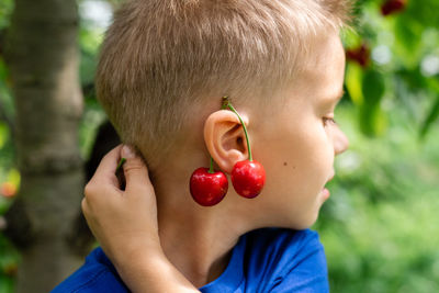 Candid portrait of a boy in the orchard during cherries harvesting.