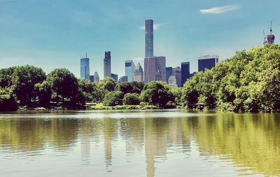 Scenic view of lake by buildings against sky