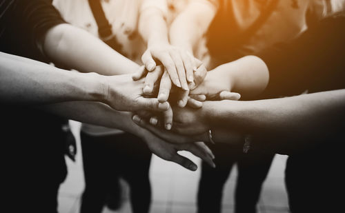 Midsection of friends stacking hands