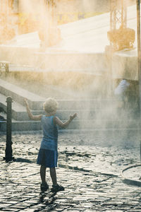 Rear view of girl standing in water