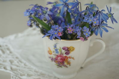 Close-up of purple flowers in cup on table