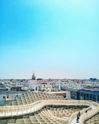 High angle view of buildings in city against clear blue sky