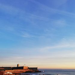 Buildings by sea against sky