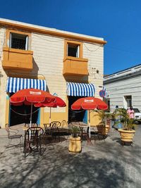 Low angle view of chairs and tables against buildings in city