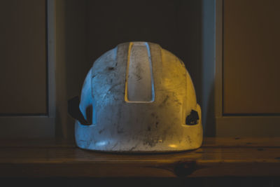 Close-up of electric lamp on table against wall at home