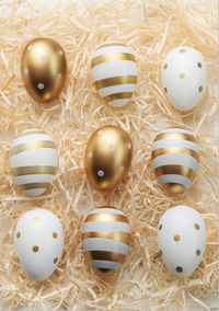 Easter eggs painted with gold paint on a straw background. concept of easter holidays. 
