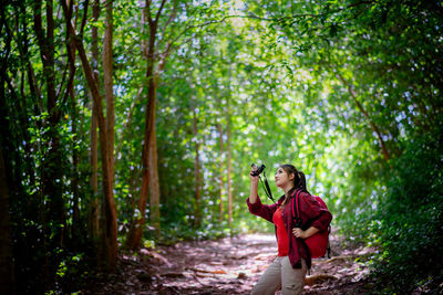 Full length of man photographing in forest