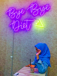 Full length of boy holding text on wall