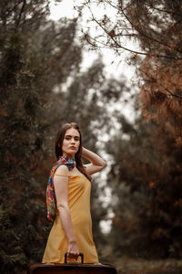 Portrait of young woman standing in forest