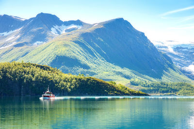 Scenic view of lake by mountains against sky