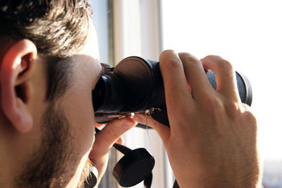 Close-up of man photographing against the sky