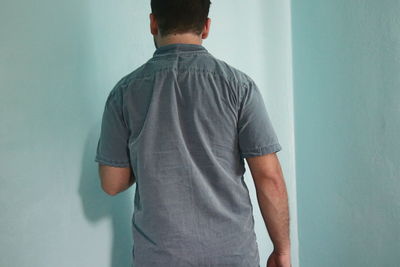 Rear view of man standing against wall