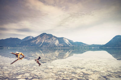 Broken tree branches in water of silent lake in european dolomite alps. calm water surface mirroring