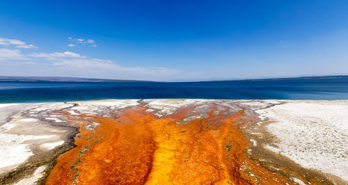 Close-up of beach against blue sky