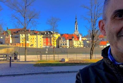 People walking in front of building against clear sky