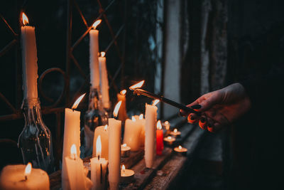 Person holding burning candles in temple