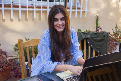 Businesswoman using laptop at table outdoors