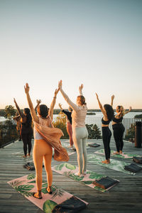 Female friends with arms raised standing together on patio at retreat center