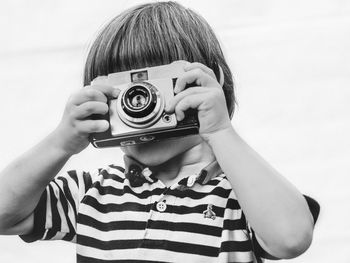 Portrait of boy photographing against sky