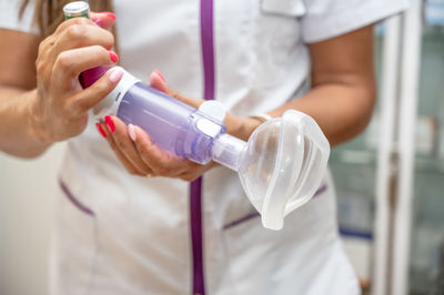 Midsection of doctor holding bottle