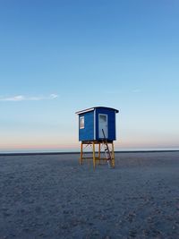 Lifeguard hut on beach against sky