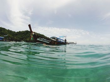 Boat floating on sea against sky