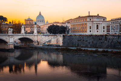 Arch bridge over river against buildings in city