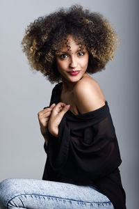 Portrait of young woman against white background