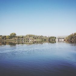 Scenic view of river against clear blue sky