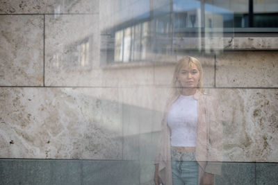 Double exposure of beautiful young woman standing in front of building