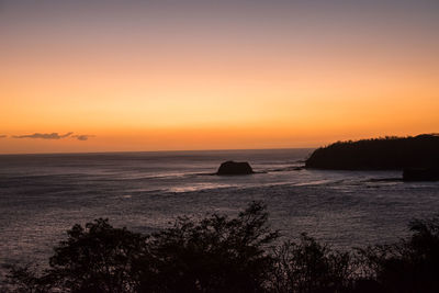 Scenic view of sea against orange sky