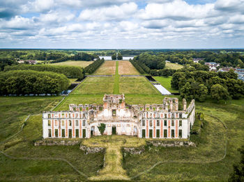 High angle view of old ruin palace amidst garden against cloudy sky