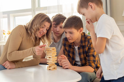 Happy family , in room play a board game made of wooden rectangular blocks