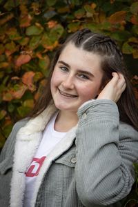 Portrait of a smiling young woman with autumn leaves