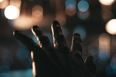 Midsection of person with illuminated lights at night